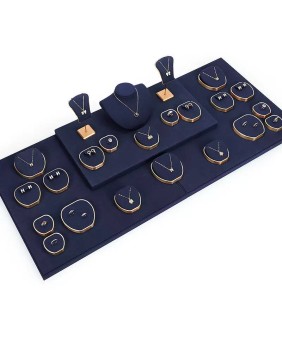 Exhibición de conjunto de joyas de metal dorado de terciopelo azul marino